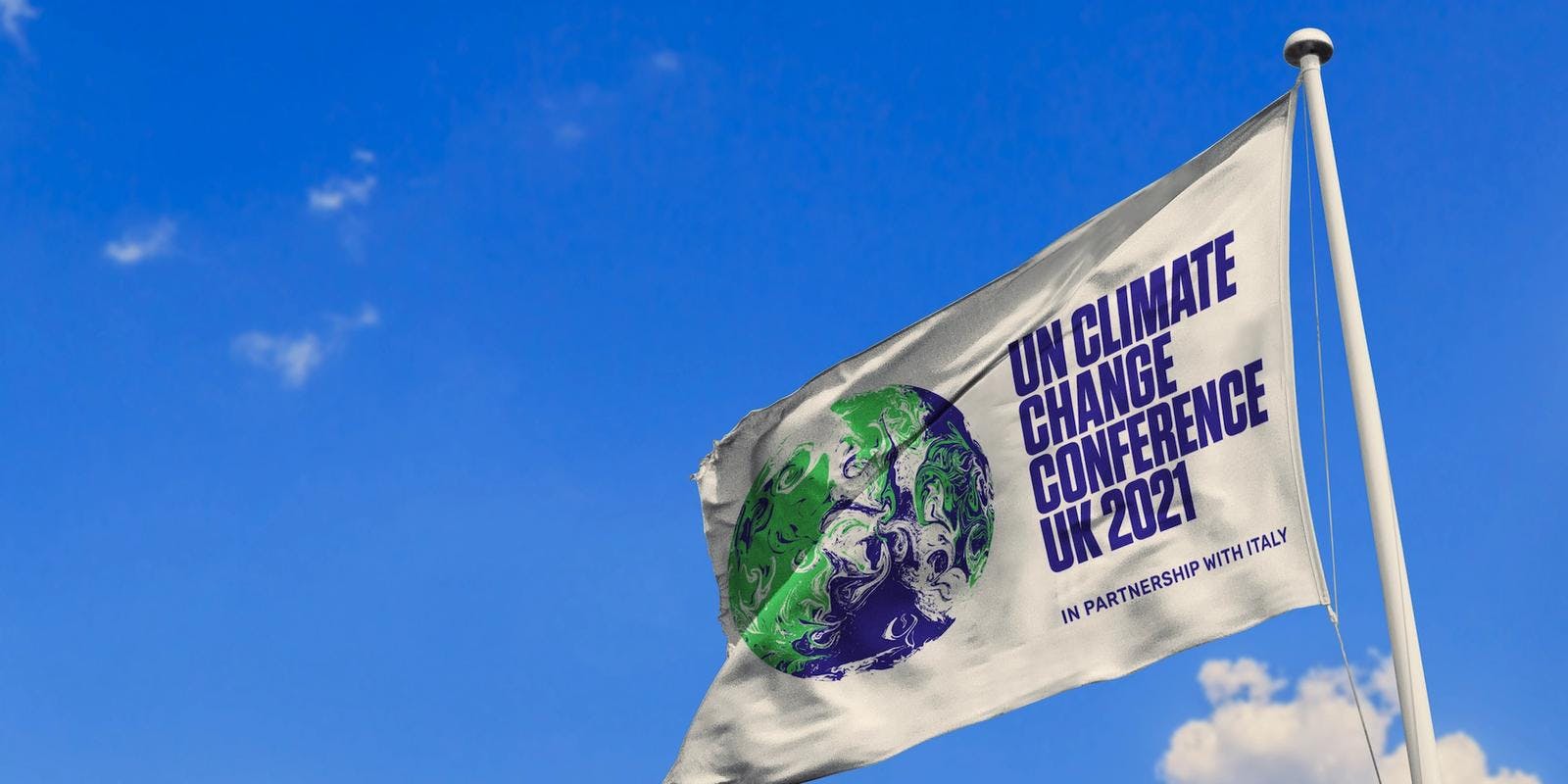 UN Climate Conference flag flying at the top of a flagpole in front of a bright blue sky